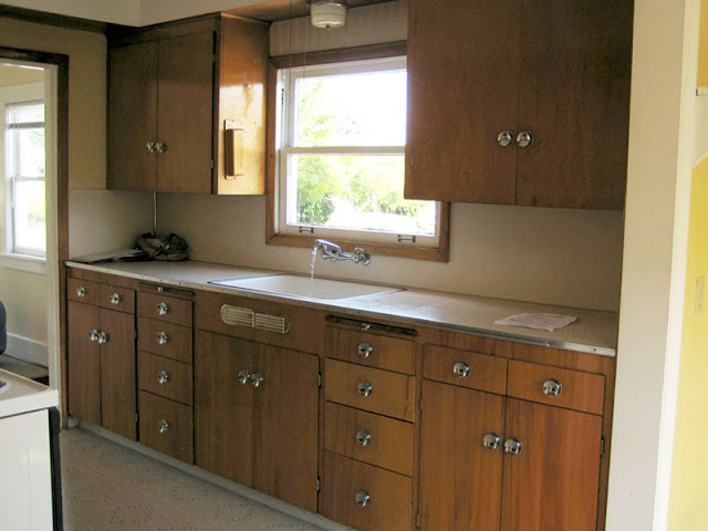 Kitchen before it's Tom Newman inspired makeover with wood drawers and cabinets and light brown title floor 