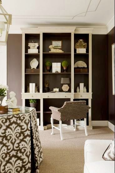 Sitting room with brown walls, grey carpet floor, detail trim painted on the ceiling, built in shelves and a brown polka dot upholstered sette