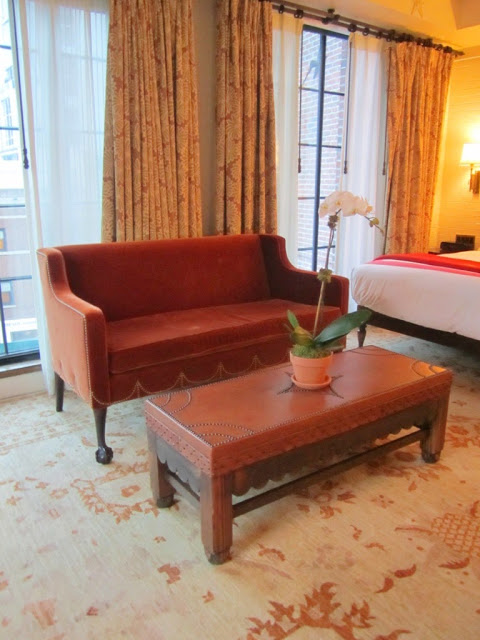 Leather sofa and matching ottoman with nail head trim in at The Bowery Hotel