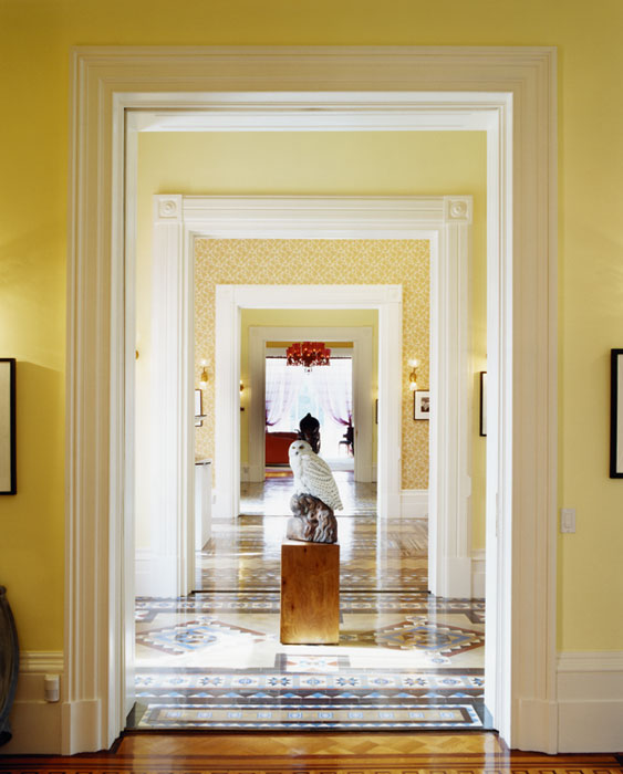 Yellow enfilade with a tile floor and a sculpture of a white owl in the center