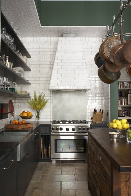 Kitchen with dark wood cabinets, floating shelves, subway tile backsplash, stainless appliances, a hanging pot rack and an island with stained wood cabinets and a wooden counter top