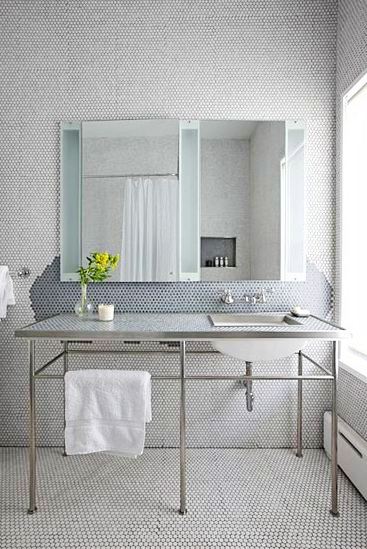 Bathroom with white penny round tile on the walls and floor and a console sinks