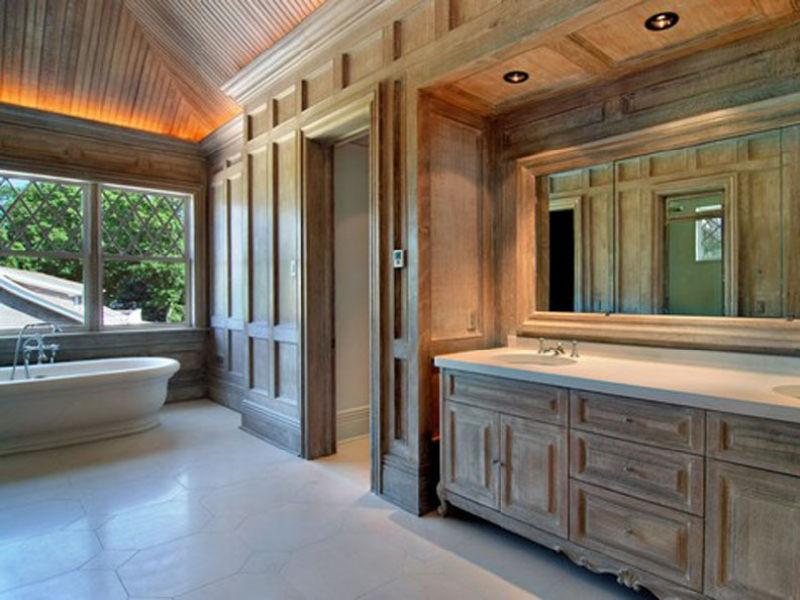 Master bathroom with tile floor, wood paneled walls and cabinets, wood ceiling and a stand alone tub