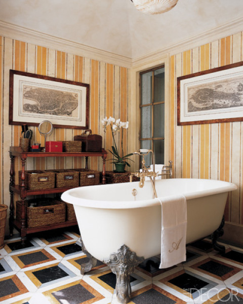 Bathroom with a claw foot tub, yellow and white striped wallpaper, decorative moudling, and a black, gold and silver tile floor
