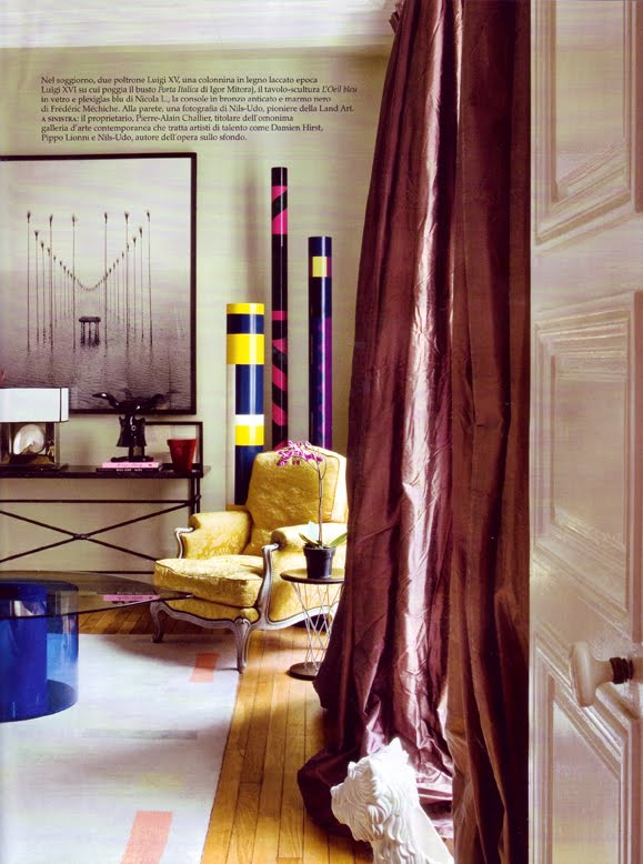 Sitting area with glass coffee table with a a Yves Klein blue base, taffeta curtains and a yellow Louis XIV armchair