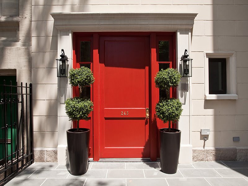 Townhouse in NYC with a bright red door and limestone facade
