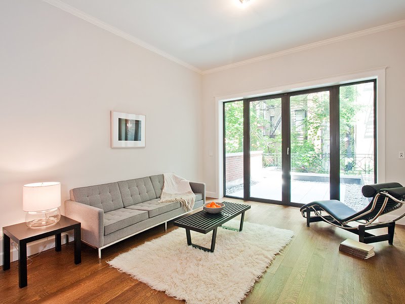 Living room in a LEED certified townhouse with grey upholstered sofa, shag rug and black Le Corbusier chaise lounge
