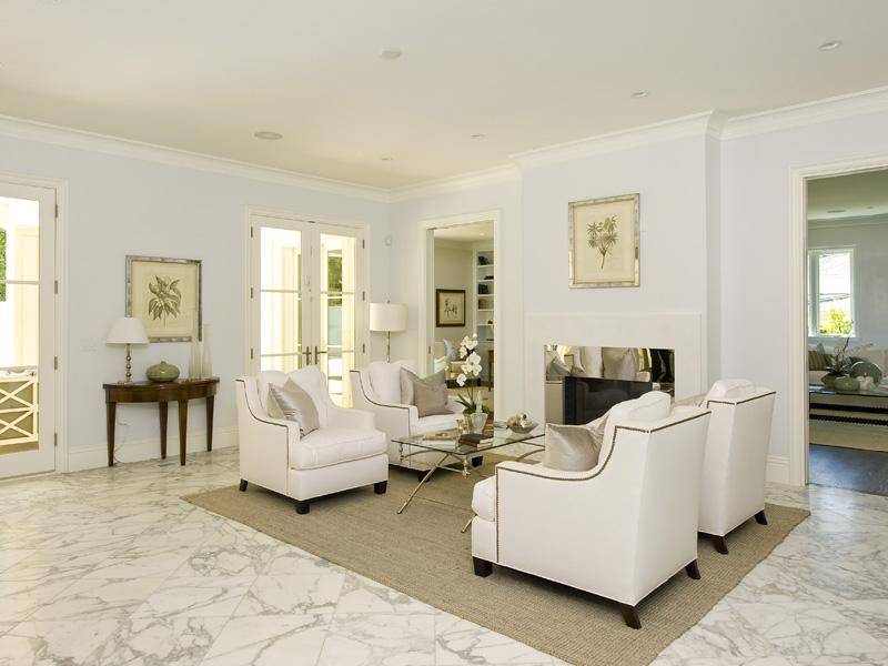 Living room with marble tile floor and white armchairs with nail head trim
