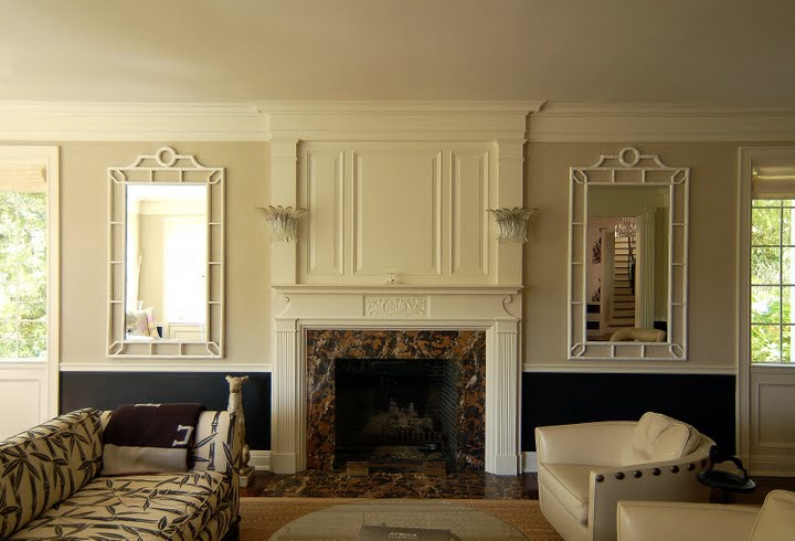 Formal living room in a remolded and restored Regency home by Kevin Oreck with black wainscoting, white fireplace mantel, faux bamboo mirrors and a sofa with bamboo printed upholstery