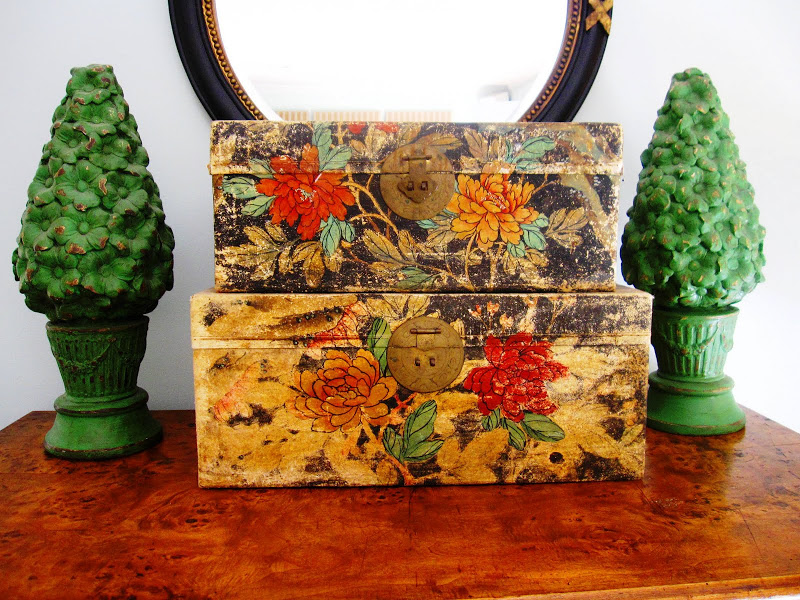 Two green wood topiaries and a two vintage floral storage boxes on an antique dresser