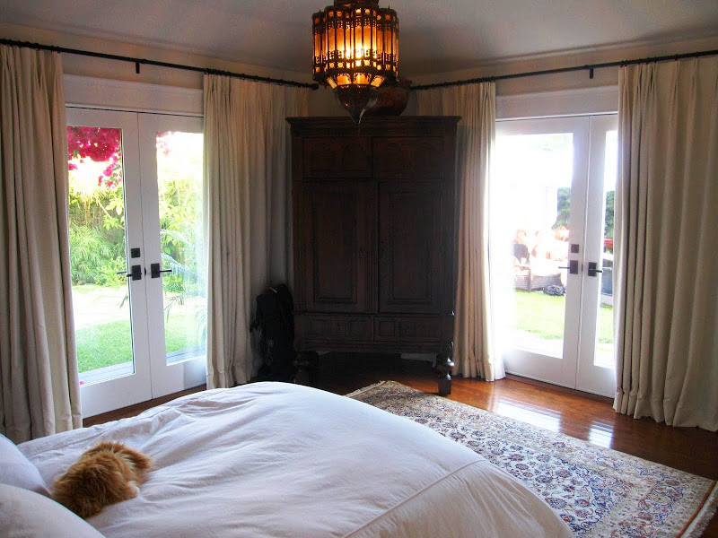 Bedroom in a beach house with a large Moroccan style metal lantern, wooden wardrobe and a Persian rug