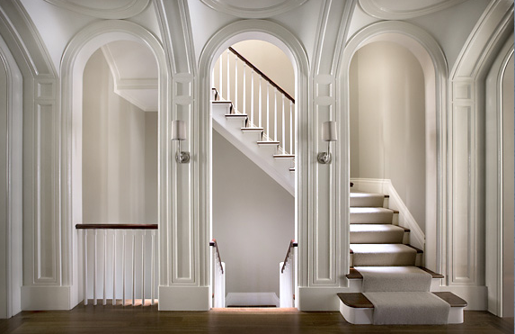 Landing in a New York brownstone with arched entryways by Peter Pennoyer