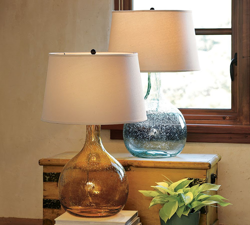 Two hand blown glass table lamps one with a gold base the other with a blue base from Pottery Barn