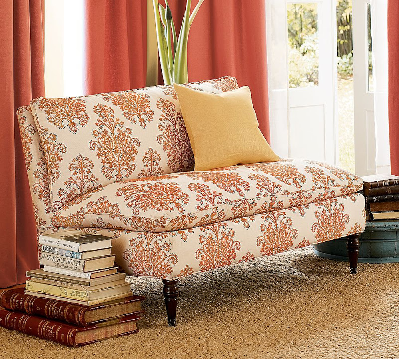 Armless loveseat upholstered in orange and white damask fabric from Pottery Barn