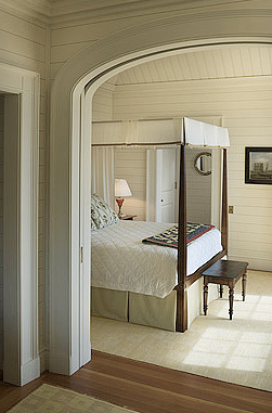 Cream colored bedroom with a wood four poster bed by Peter Pennoyer 