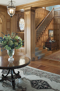 Entry hall in a home by Peter Pennoyer with wood carvings and paneling