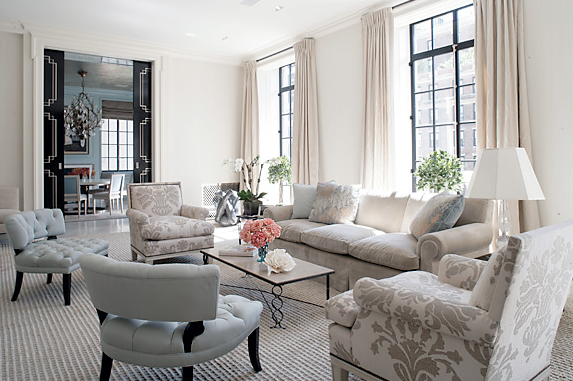 Simple and elegant grey living room by Peter Pennoyer with grey sofa, tufted armchairs, grey and white brocade armchairs and black paned windows